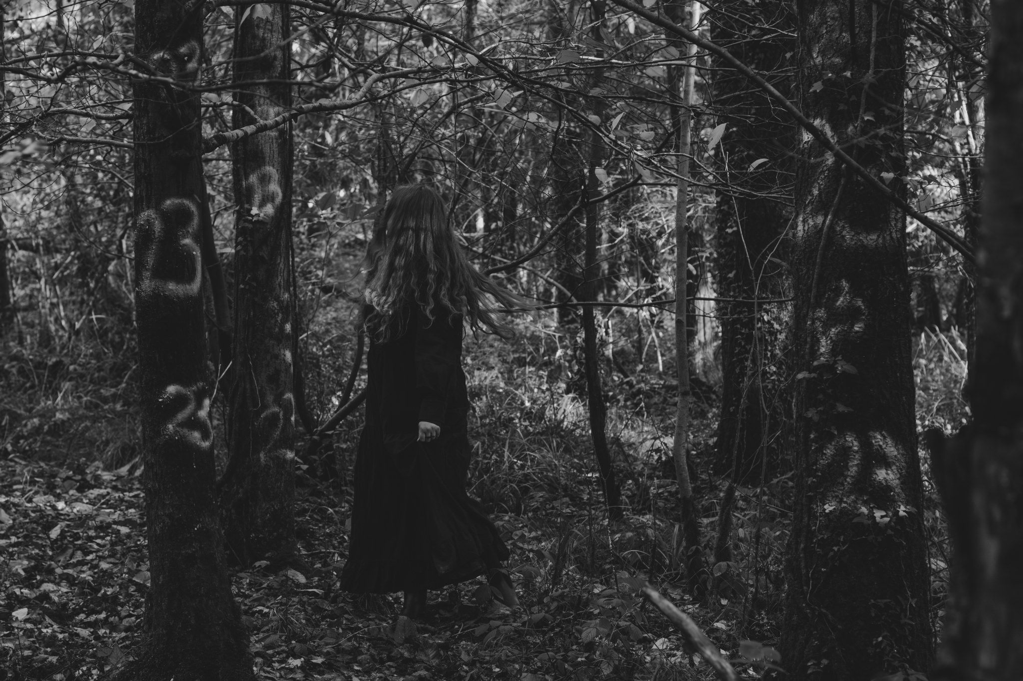 Horror Concept Photoshoot In The Woods - woman in black surrounded by the number 23