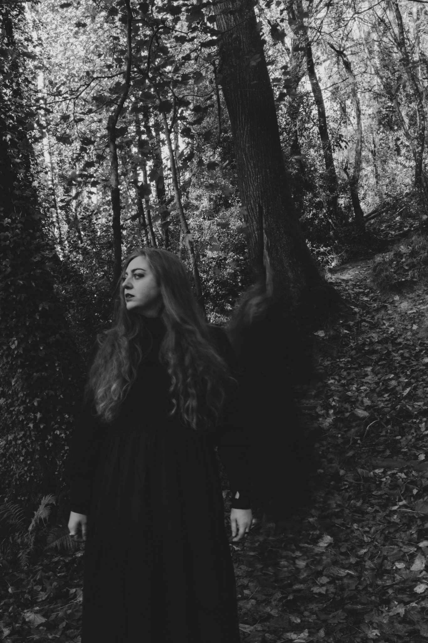 Woman in black with ghost behind her in the woods - Horror concept photoshoot