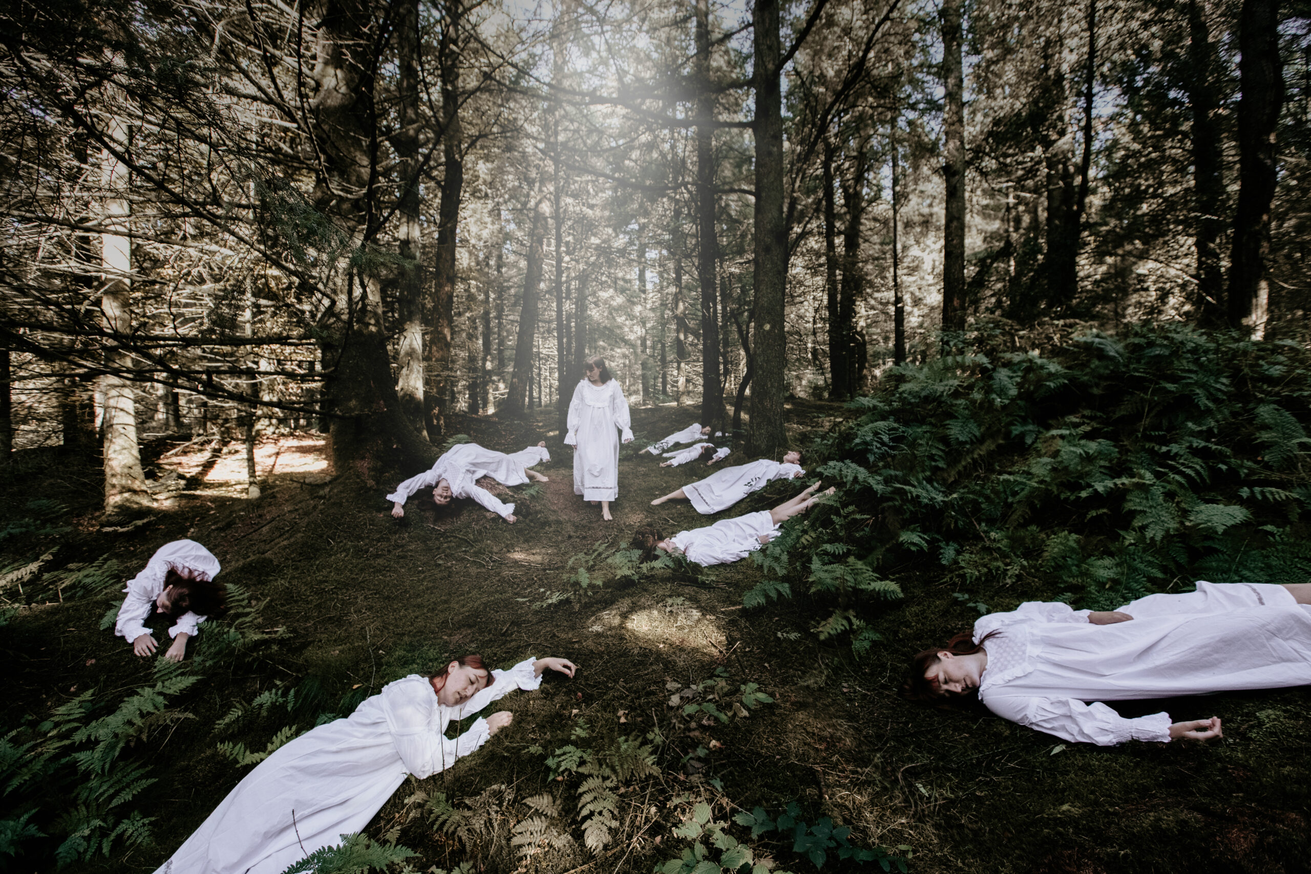 Horror photography tips - Woman walking through woods in white dress, sees her own dead bodies
